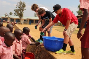Austin, Oliver, and Darren helping the kids wash their hands for lunch.